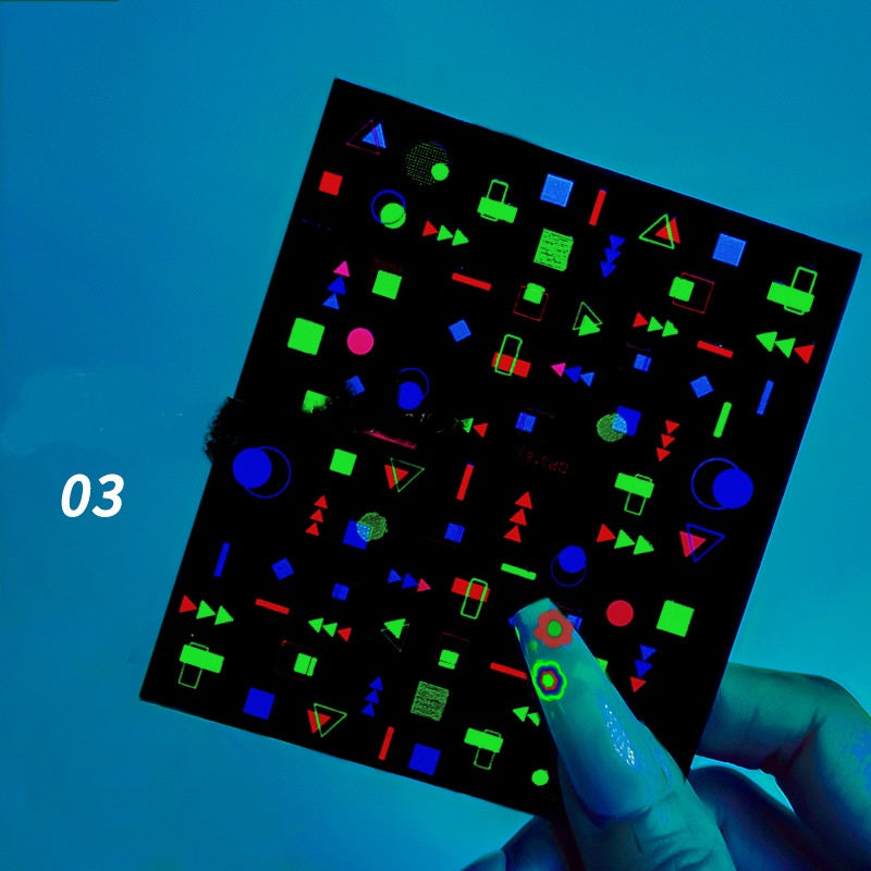 Hand holding a sheet of stickers with fluorescent shapes against a blue background