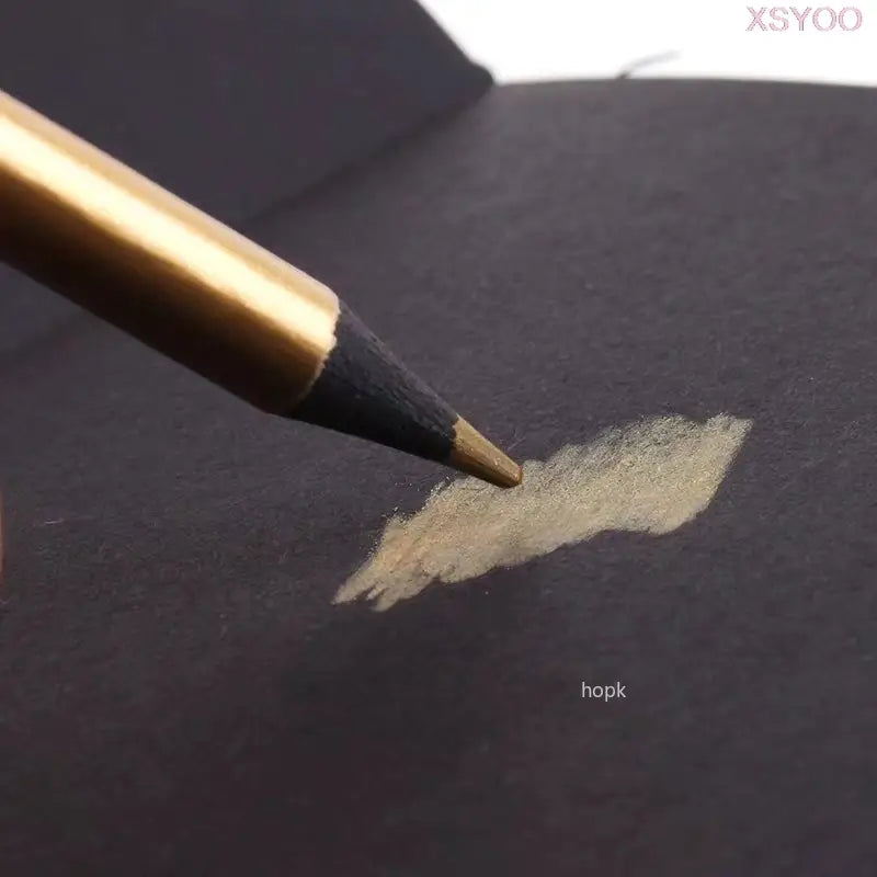 Gold Metallic pencil on a dark surface with a small swatch of color.