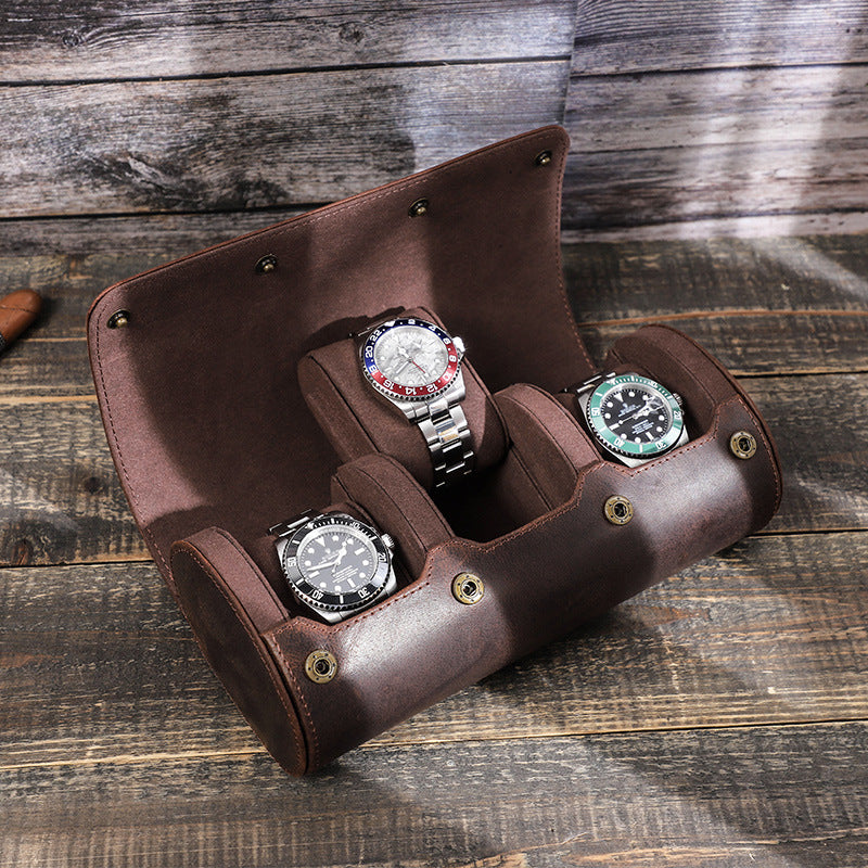 Brown leather watch holder with three Rolex watches on a wooden surface