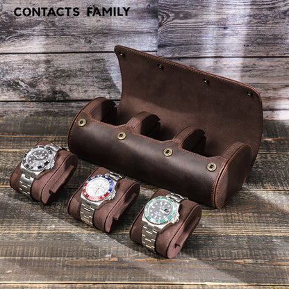 Brown leather watch holder with three Rolex watches on a wooden surface