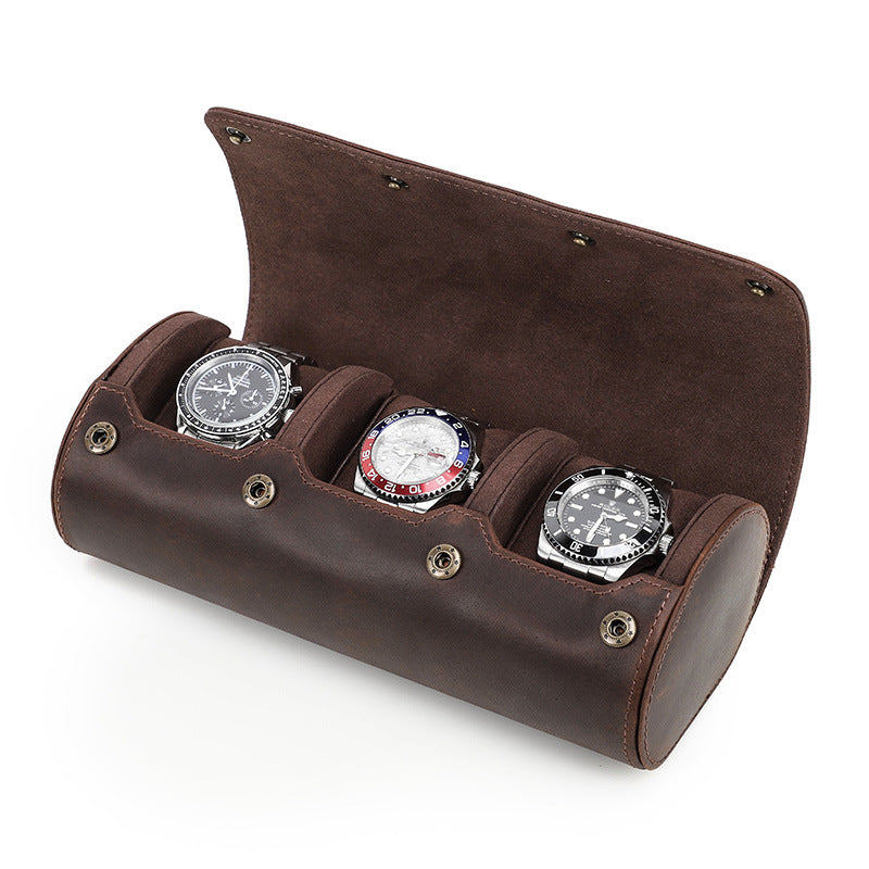 Brown leather watch holder with three watches on a white background