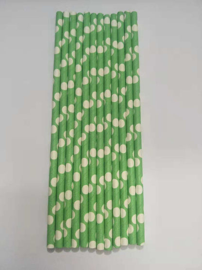 A set of paper straws with a green and white polka dot pattern, arranged vertically on a plain light gray background.