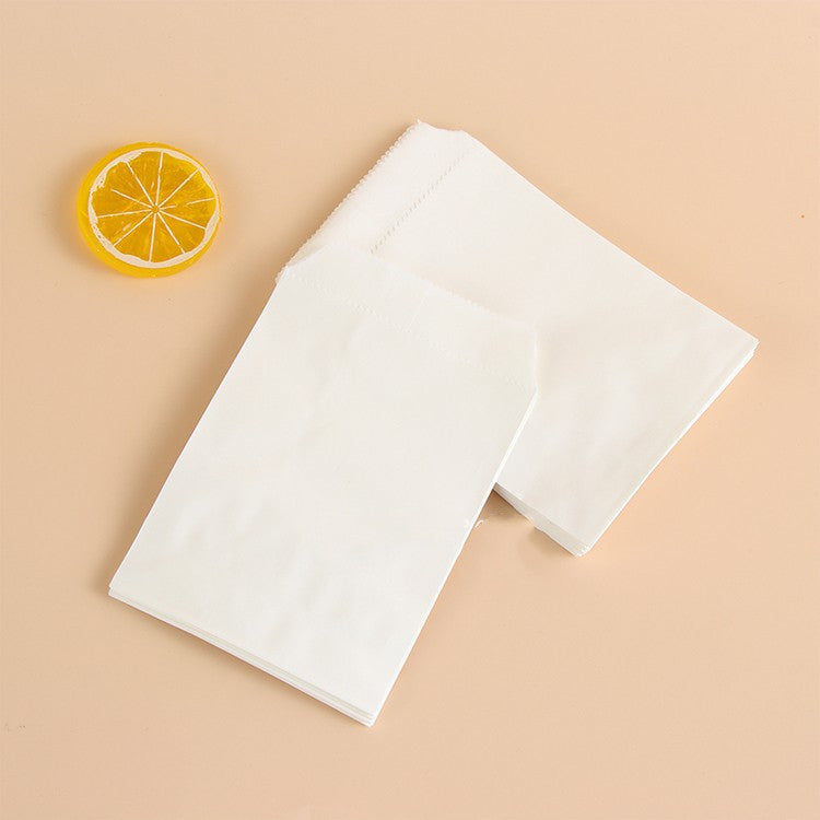 White paper bags on a beige background with a lemon wedge
