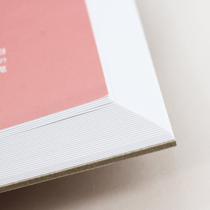 Close-up of a pink and white book corner on a light background