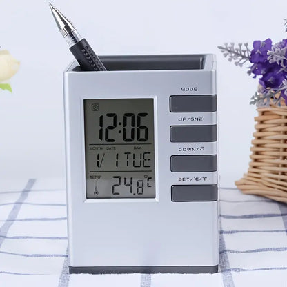 Digital clock with pen holder on a table with flowers in the background