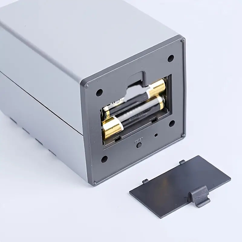 Metallic electronic component with gold contacts on a light gray background
