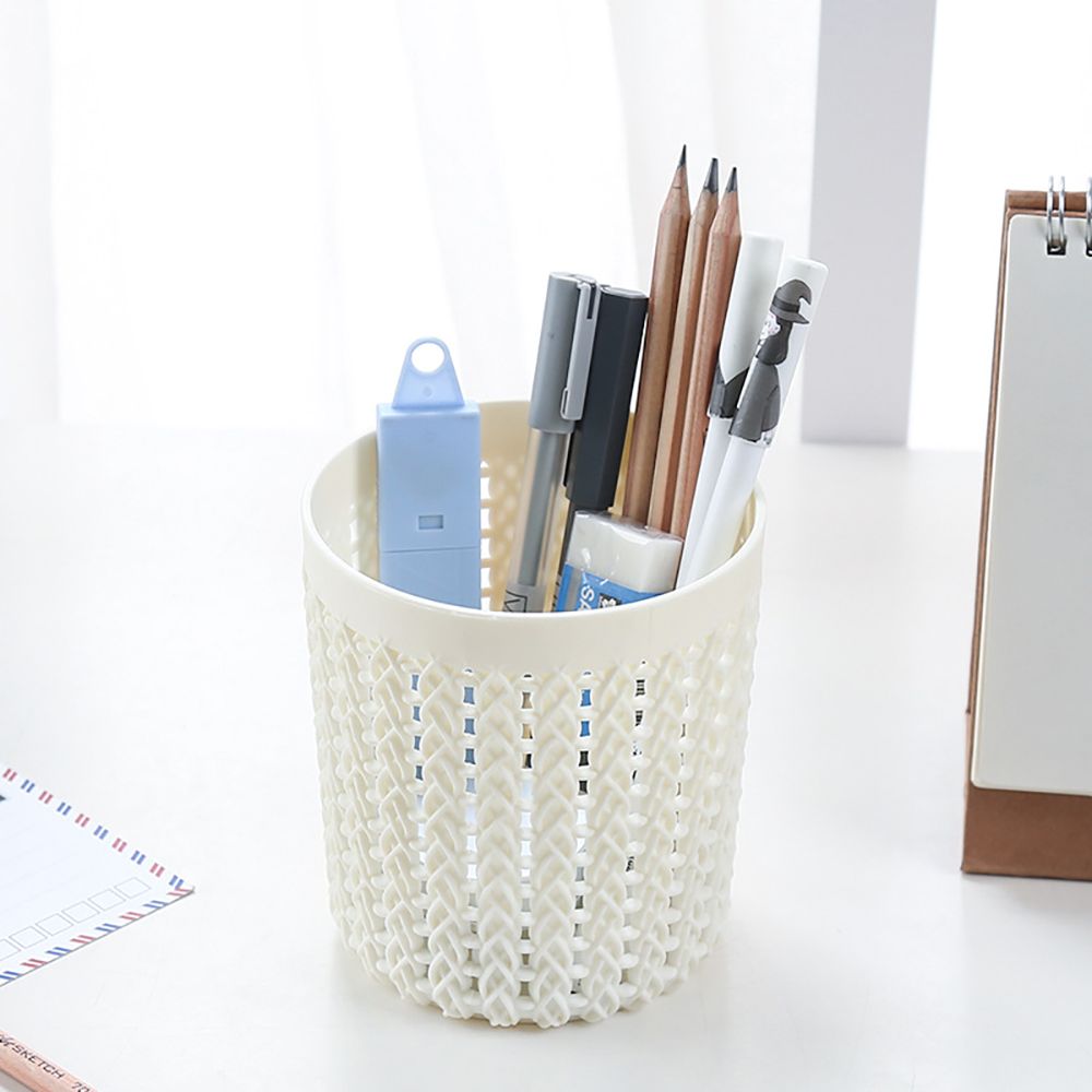 White woven pen holder with stationery items on a white background