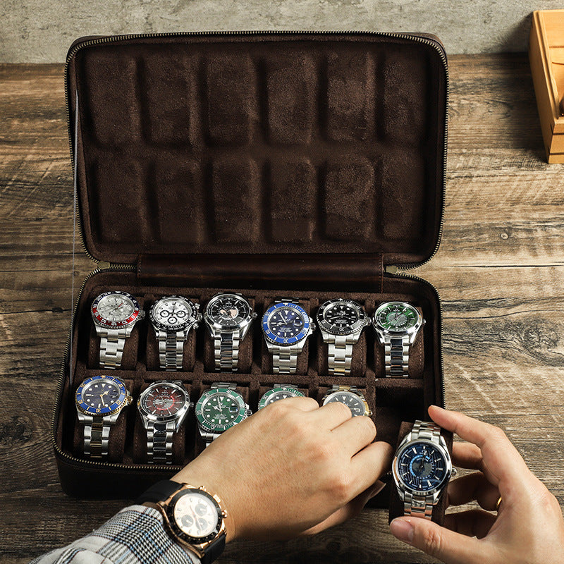 Collection of watches in a brown leather display case on a wooden surface.