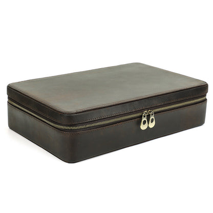 Brown leather jewelry box with gold zipper on a white background