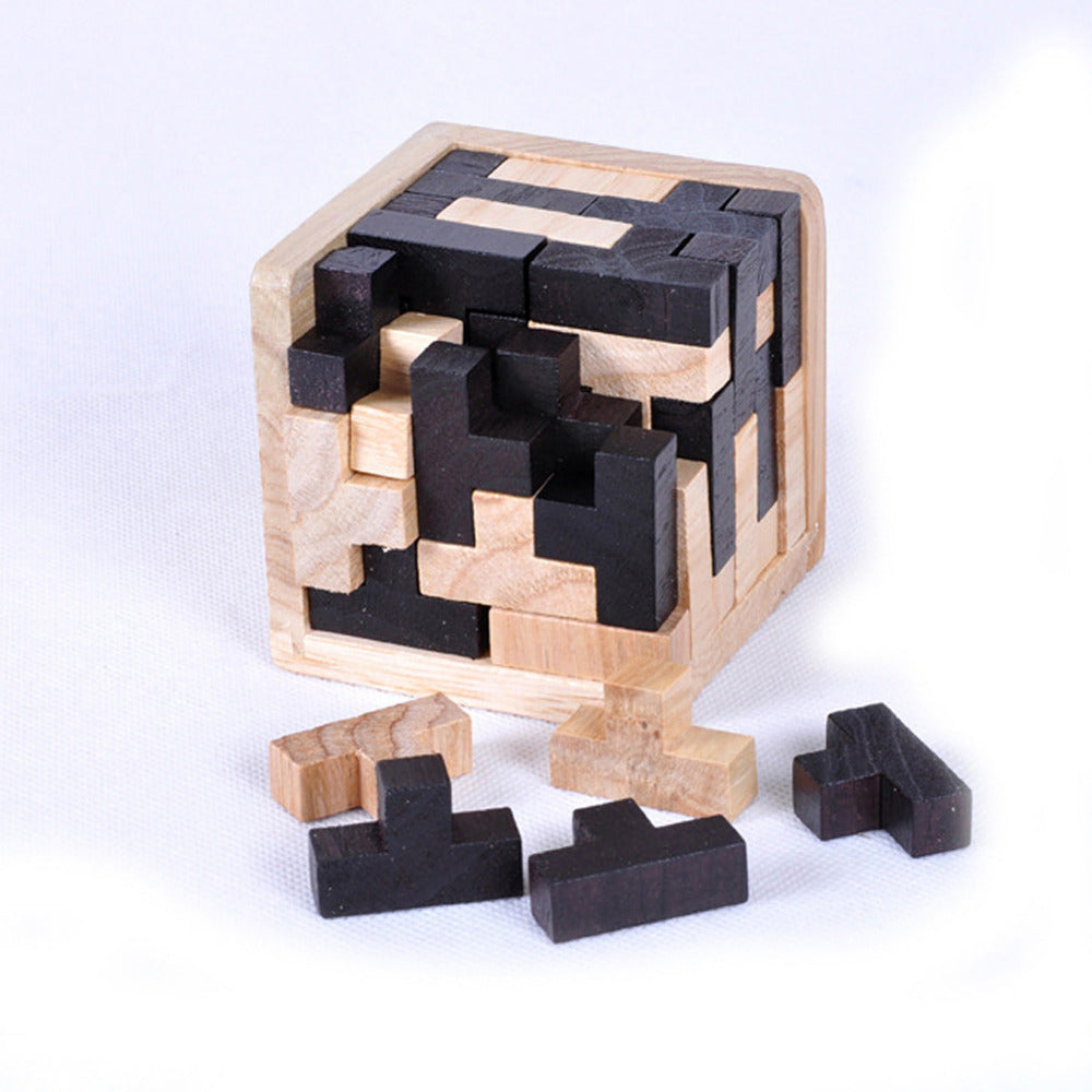 Wooden puzzle cube with black and natural wood pieces on a white background