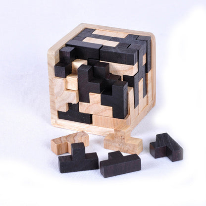 Wooden puzzle cube with black and natural wood pieces on a white background